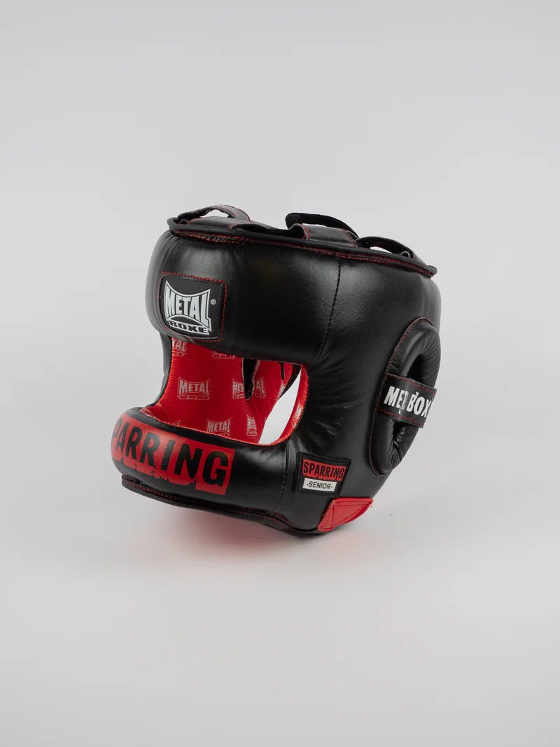 Vista frontal del casco Metal Boxing Senior Sparring negro con barra protectora y detalles en rojo