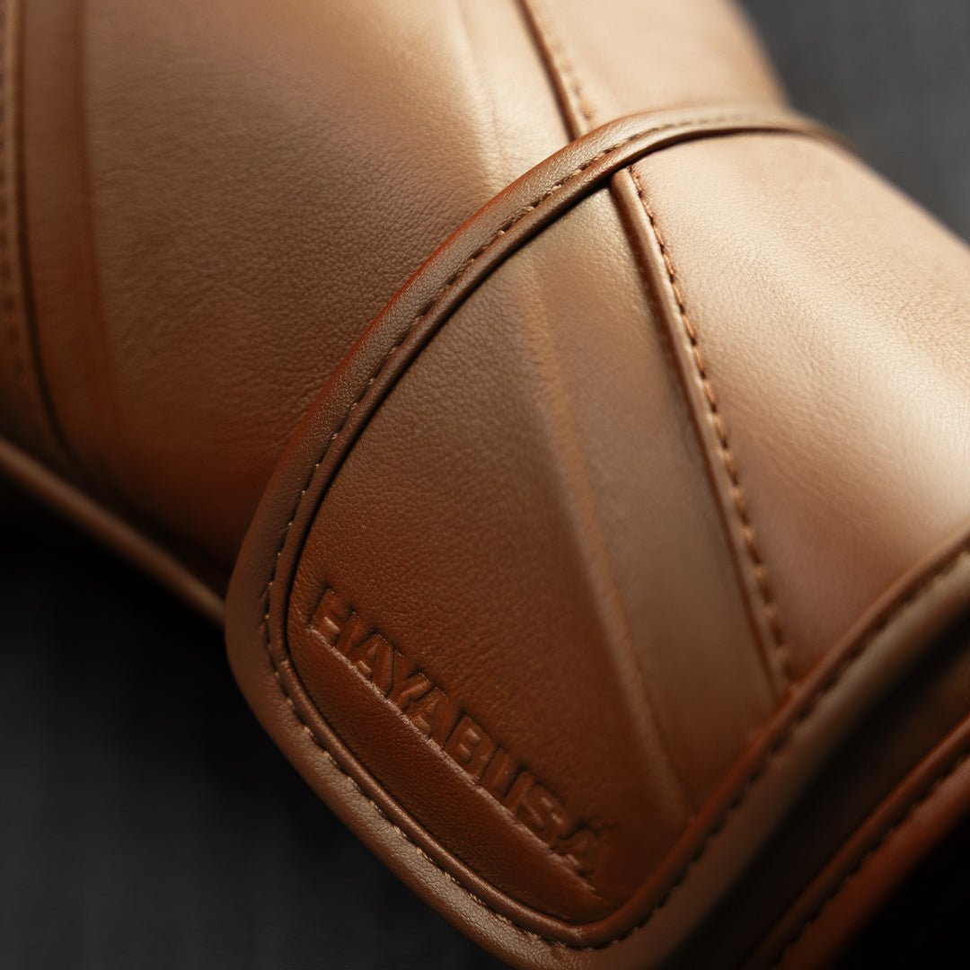 Detalle de la tira elástica marrón de los guantes Hayabusa E1, diseñada para estabilizar la muñeca