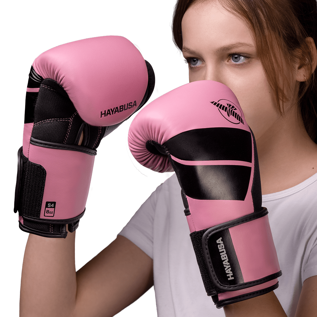 Menina com as luvas rosa Hayabusa S4 usadas para bater no saco