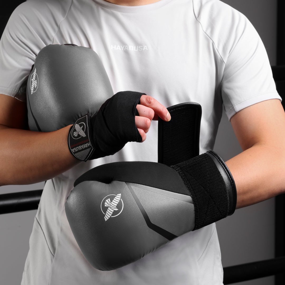 Luvas de boxe cinza Hayabusa E1 usadas ao acertar luvas de foco