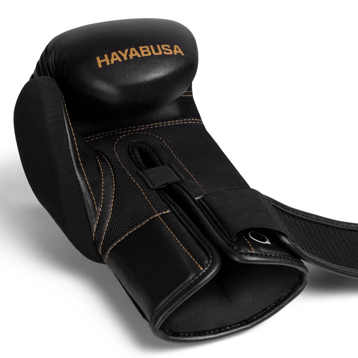 Close do fecho de velcro aberto na luva Hayabusa E1 preta e dourada