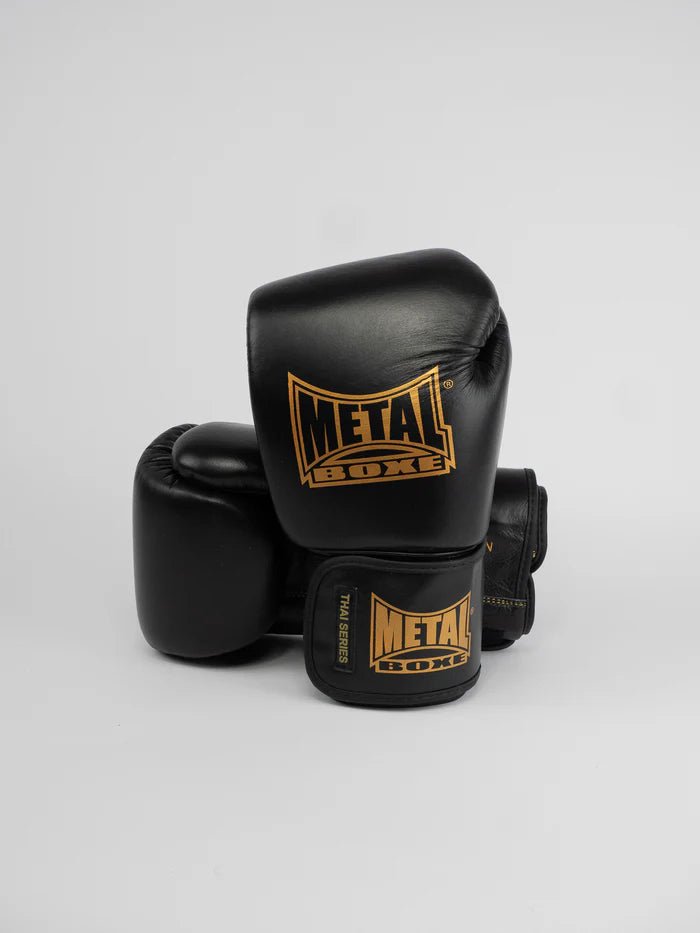 Vista frontal das luvas Metal Boxing Thai Series em couro de flor integral preto e dourado
