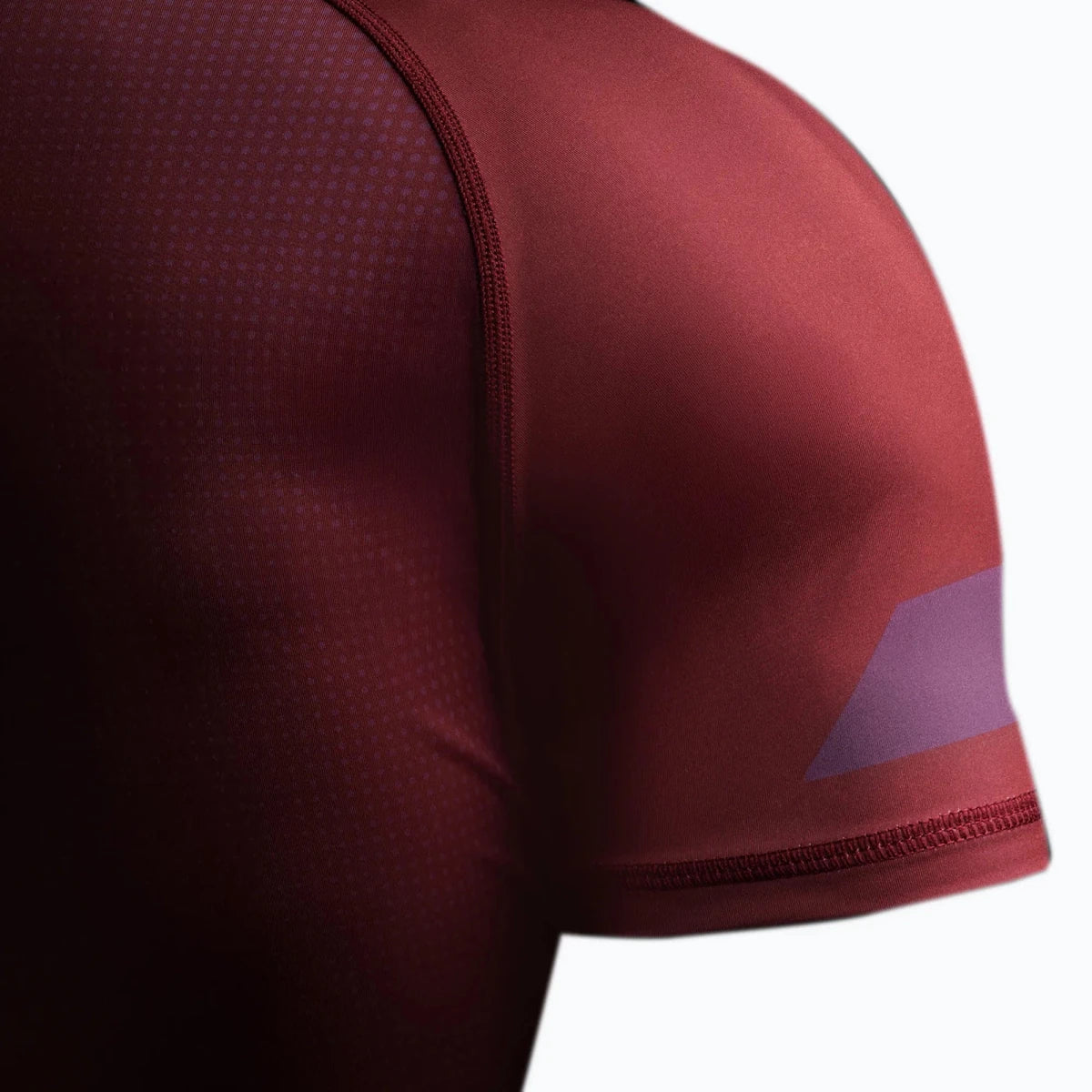 Detail of the silicone anti-slip edge on the burgundy rash guard.