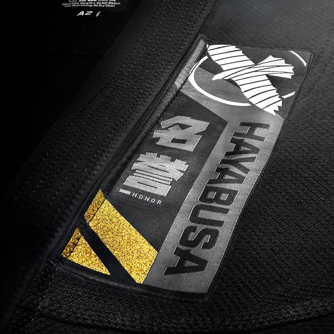 Close-up detail of the kanji patches and trim on the black Ascend Gi jacket