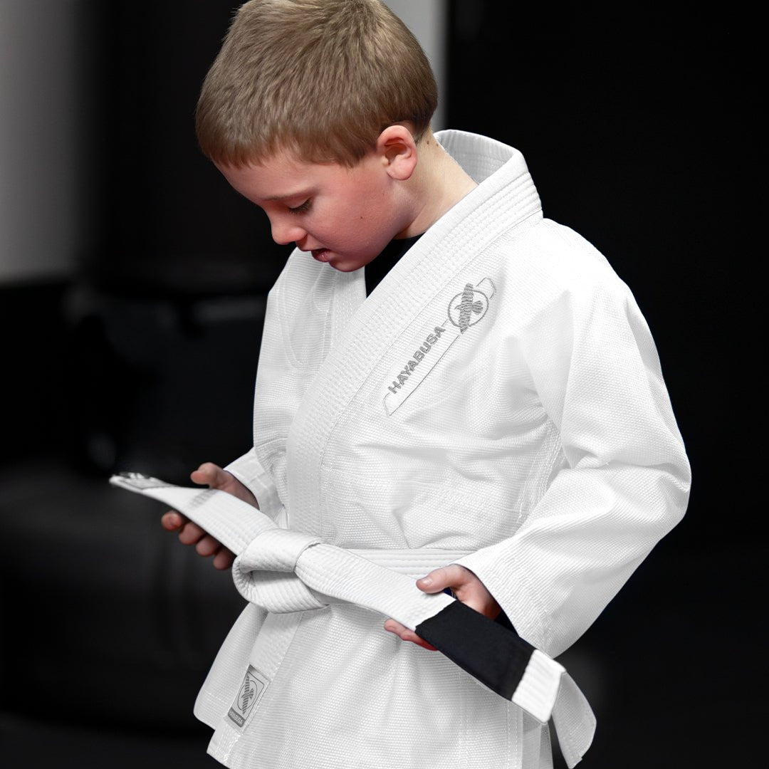 Ein Kind trainiert auf der Tatami und trägt den weißen Hayabusa Essential BJJ-Kimono