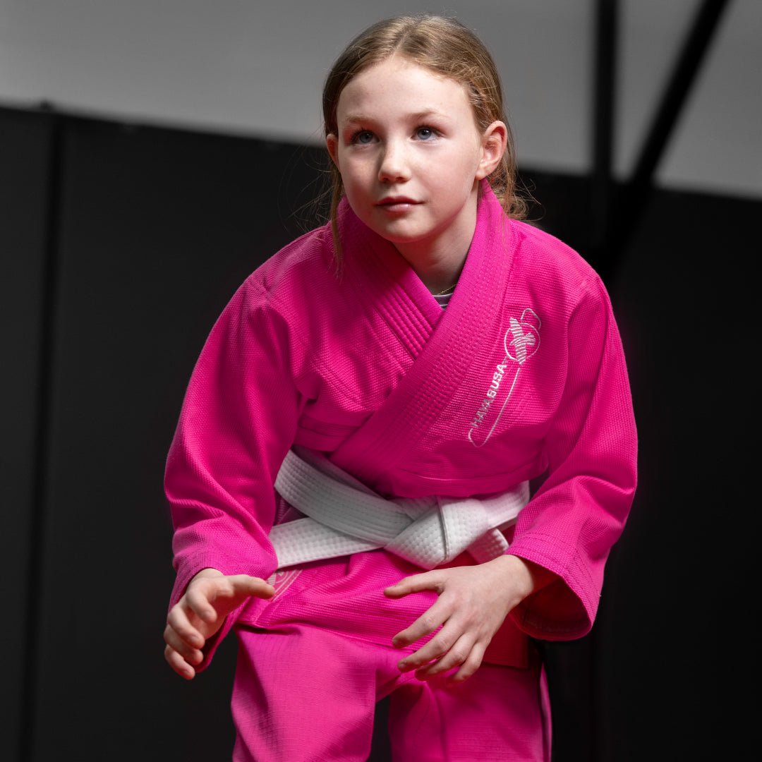 Kleines Mädchen während einer Jiu-Jitsu-Sitzung im rosa Hayabusa Essential-Kimono
