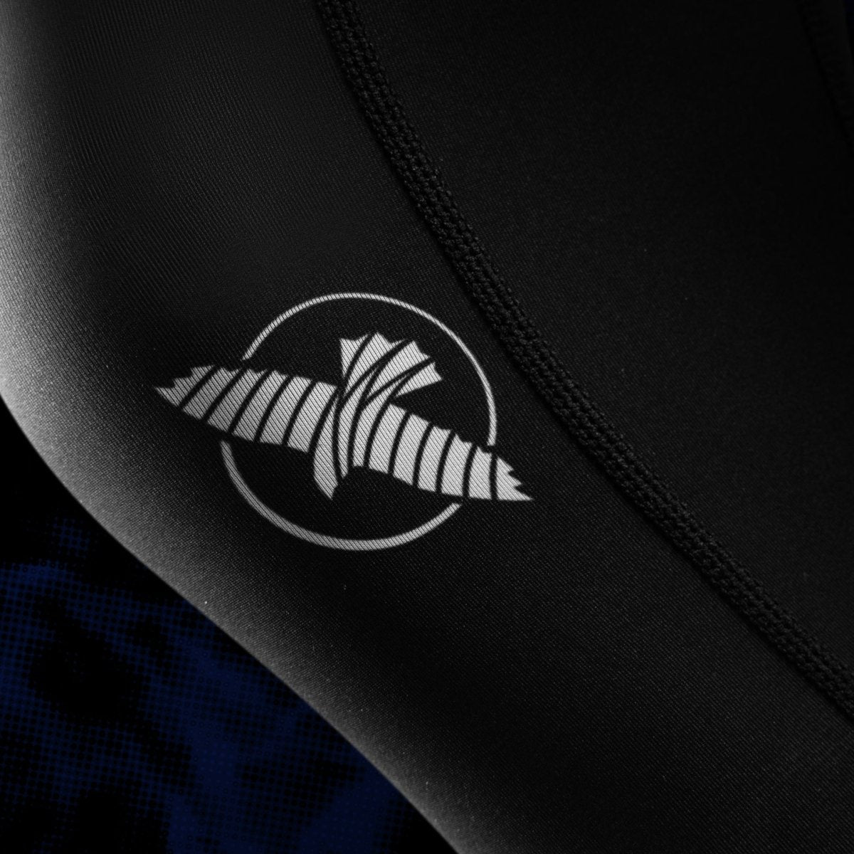 Close-up detail of the UFC writing printed on the leg of the black and blue women's BJJ leggings