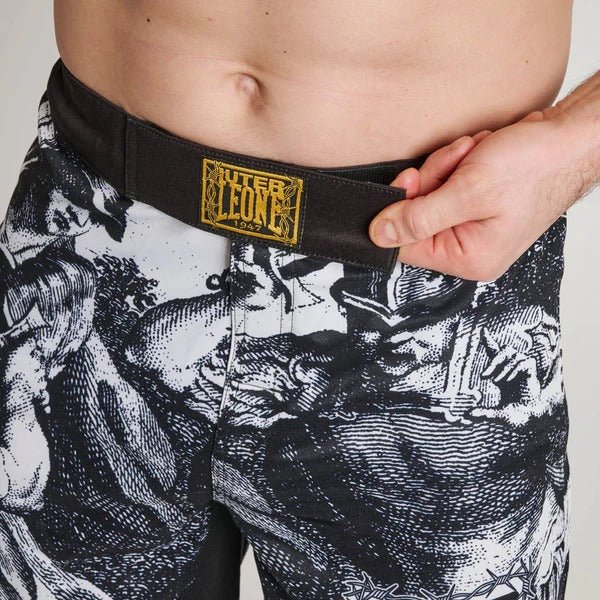 Nahaufnahme des vorderen Verschlussbereichs der LEONE x IUTER-Shorts mit Blick auf den internen Kordelzug und den Goldfaden-Patch am Bund