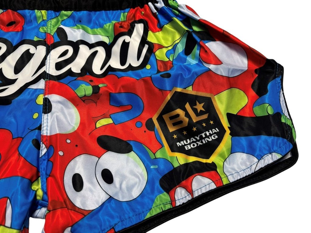 Detalle de los coloridos gráficos pop-art de los pantalones cortos de kickboxing para niños.