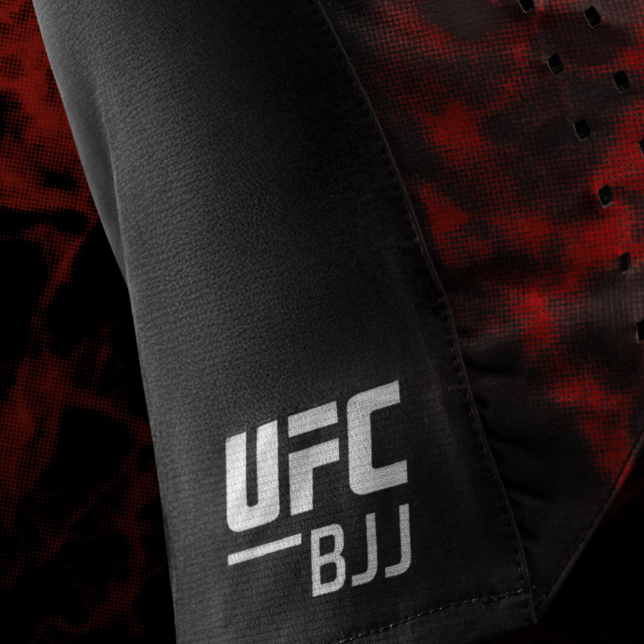 Primo piano del logo laterale UFC BJJ sui pantaloncini da grappling donna neri e rossi
