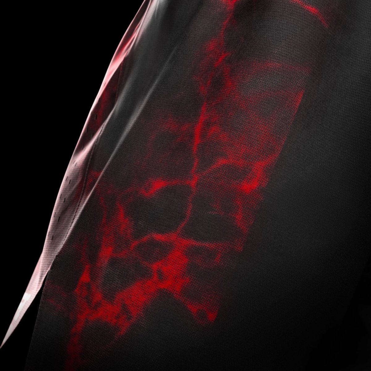 Vista lateral del short negro y rojo de UFC BJJ, detalle de las ventilaciones para movilidad y ventilación láser.