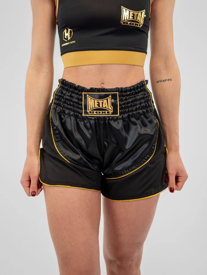 Vista frontal pantalón corto de Kickboxing mujer Metal Boxe Siam negro dorado satinado