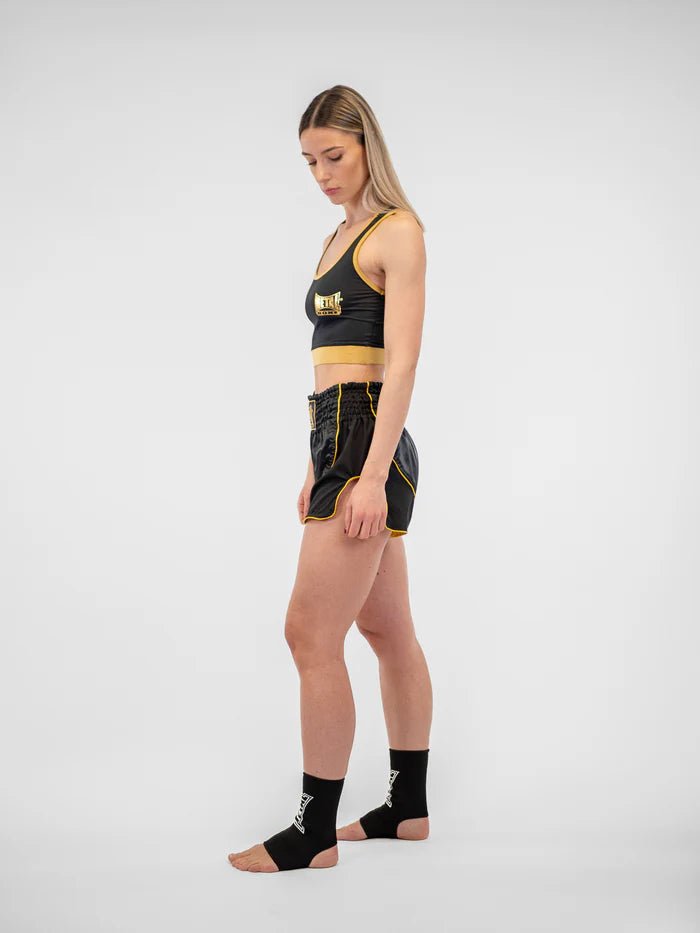 Vista lateral del short Metal Boxing Siam negro dorado para mujer, detalle de la ventilación