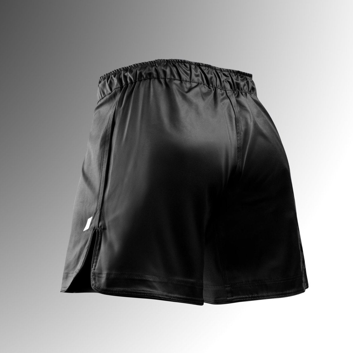 Vista trasera de los pantalones cortos negros de MMA Hayabusa Apex Mid-Thigh MMA, que muestra la cintura segura y la tela resistente a desgarros.