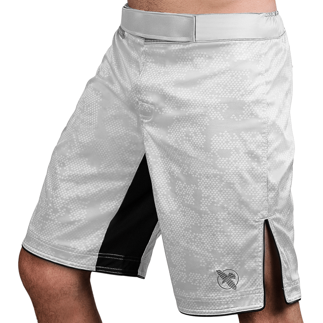 Vista lateral (lado 1) de los pantalones cortos blancos de MMA Hayabusa Hexagon, corte de tabla profesional