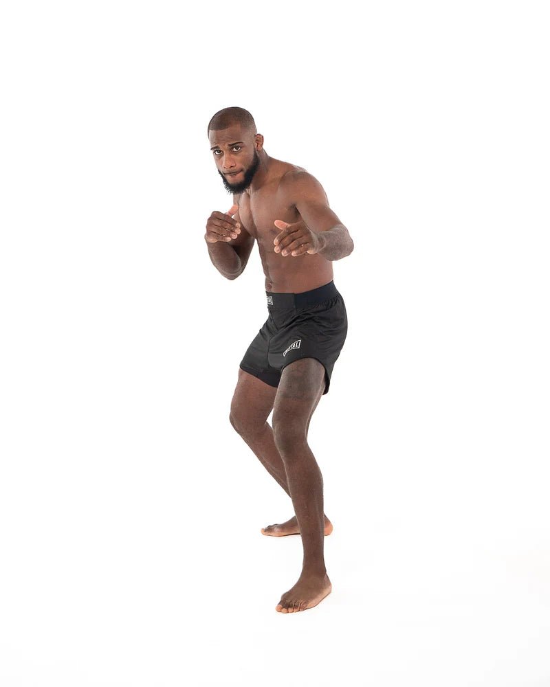 Seitenansicht: Schwarze MMA-Boxshorts aus Metall mit elastischem Einsatz am Bein