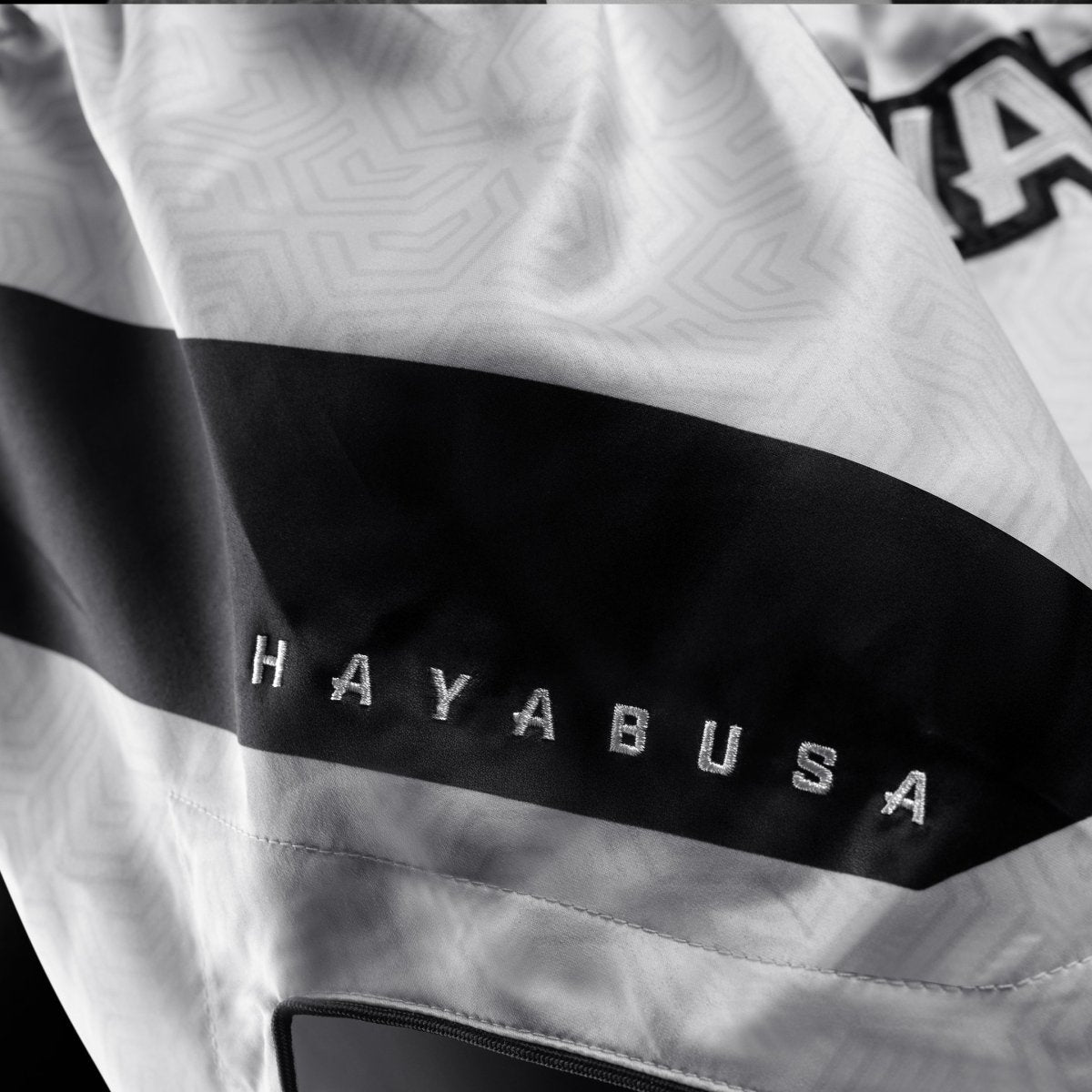Detalle del tejido técnico y logo en el pantalón corto blanco Hayabusa Core