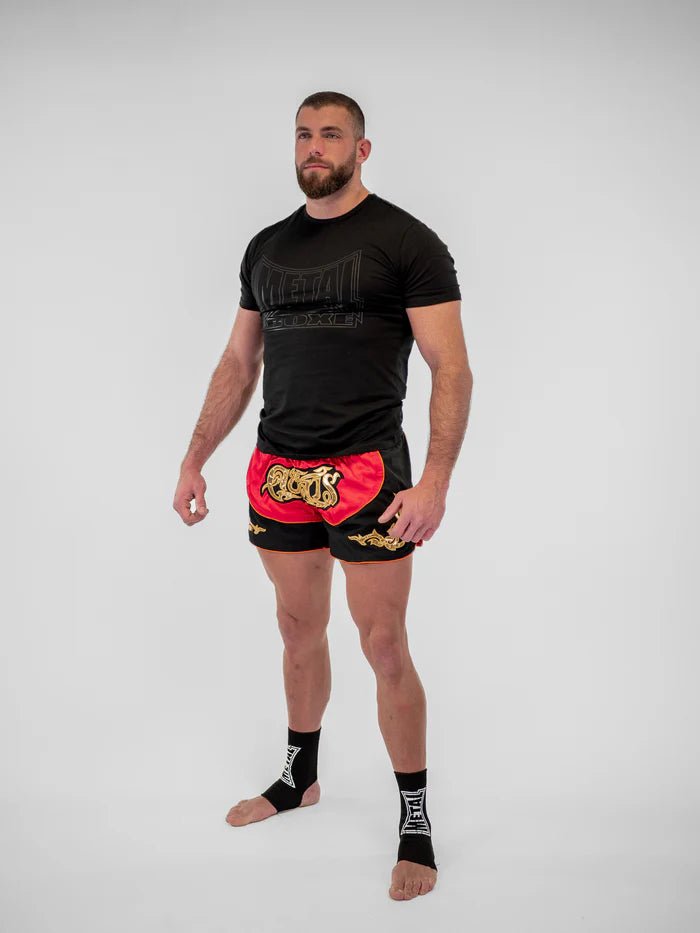 Szczegóły rozcięć bocznych i haftu czerwonych męskich spodenek tajskich Lumpinee Metal Boxing