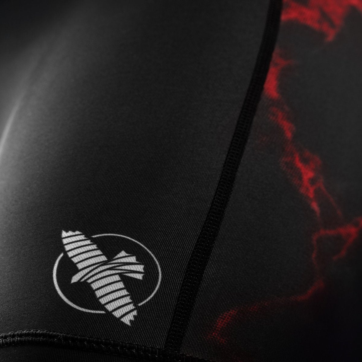 Detail of the official UFC logo on the leg of the black and red Vale Tudo women's shorts