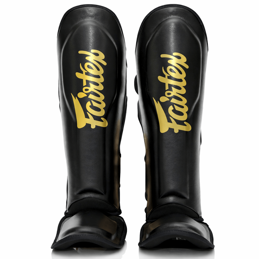 FXB Fairtex Schienbeinschutz in zweifarbiger Schwarz-Gold-Version mit Co-Branding-Logos