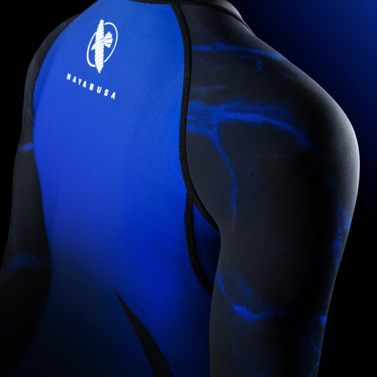 Detail of the shoulder of the black/blue UFC BJJ rash guard, highlighting the aerodynamic fit and the official design