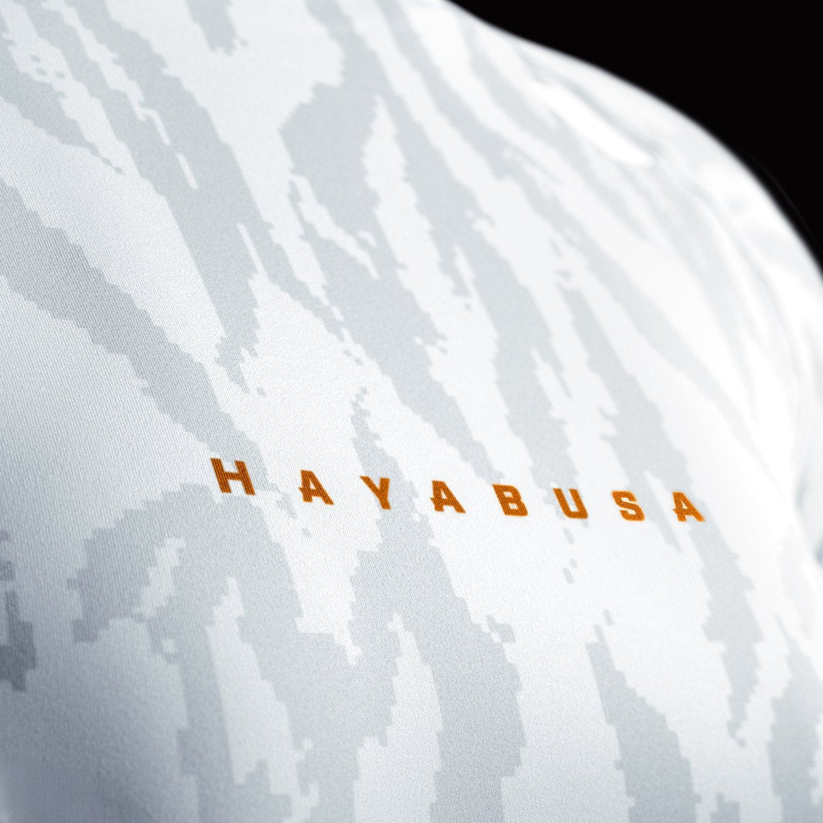Close-up of the Hayabusa front print on the white women's rashguard, detail of the bonded seam collar