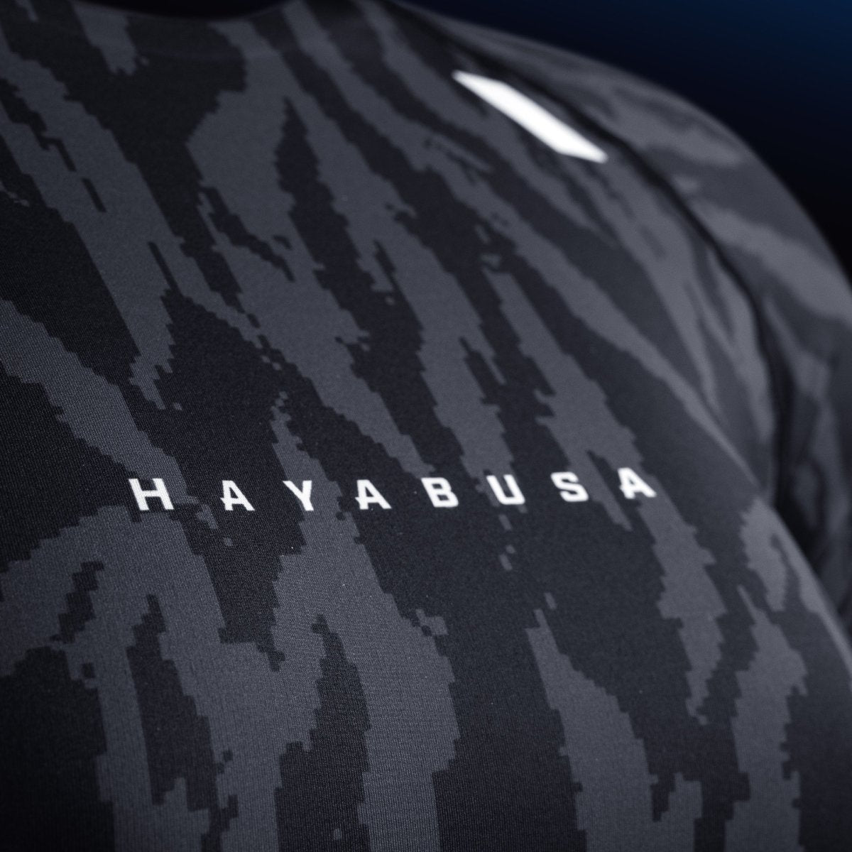 Detail of the writing and Hayabusa logo on the chest of the black rashguard, wear-resistant print