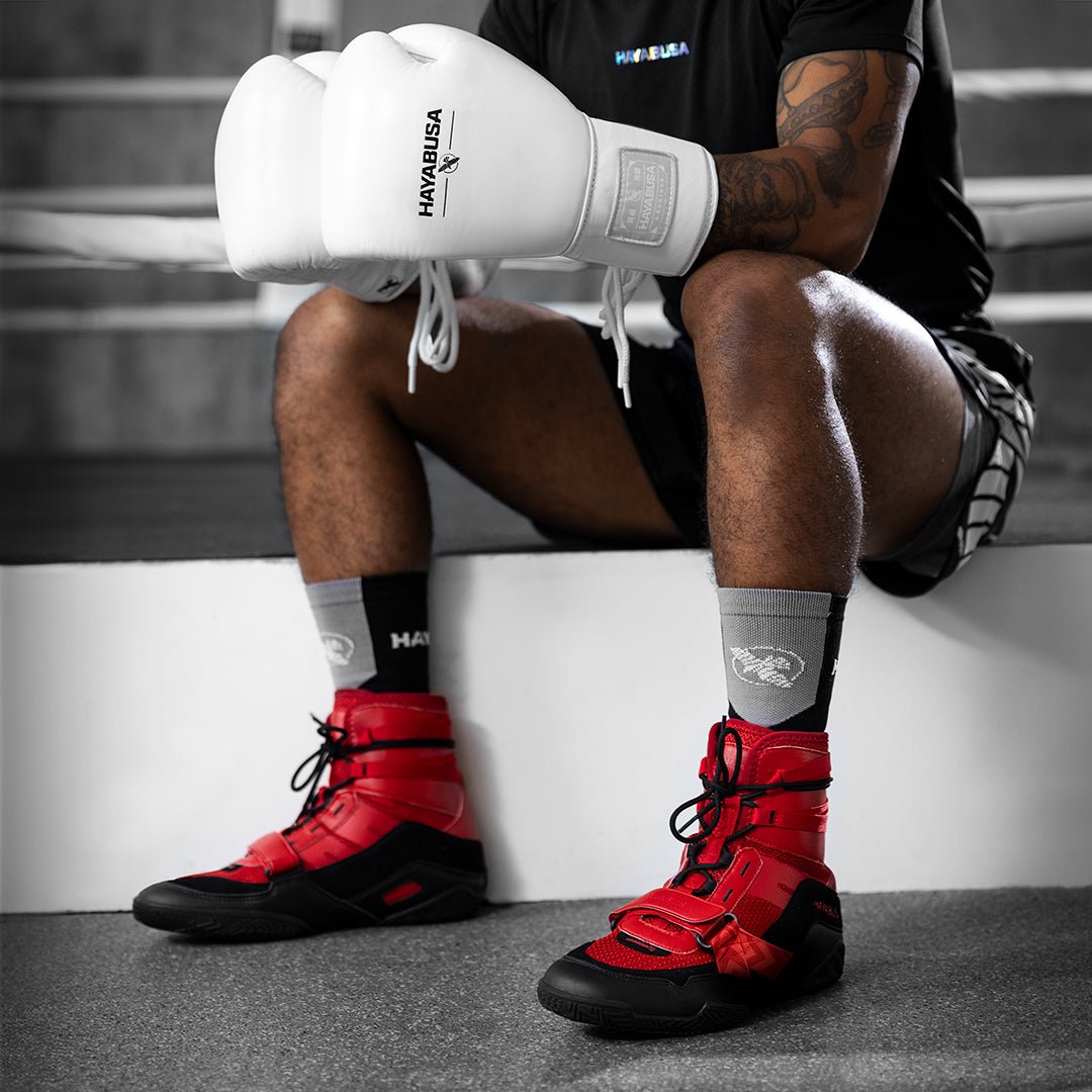 Colocando los zapatos de boxeo rojos Hayabusa Strike en un boxeador listo para el partido