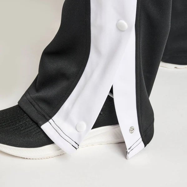 Primer plano de los botones laterales de los pantalones deportivos negros Leone Stripe