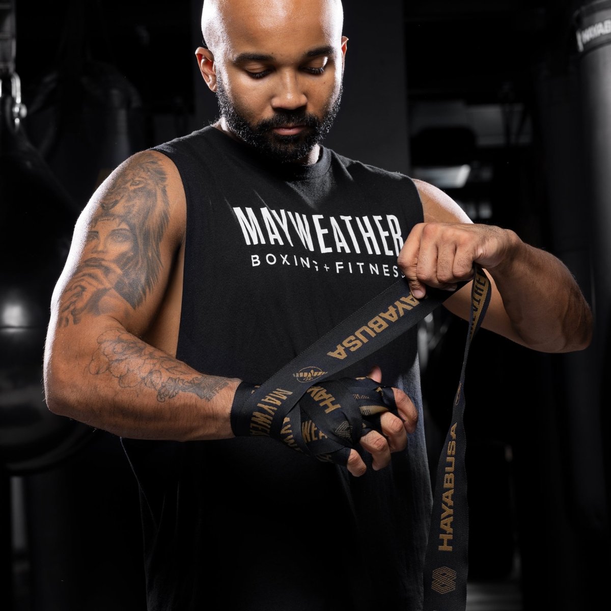 Vendaje profesional elaborado con vendas Mayweather Deluxe negras y doradas en mano y muñeca.