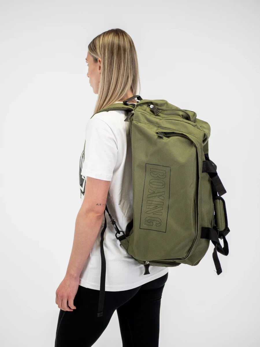 Atleta que lleva la bolsa de lona Metal Boxe Khaki en modo mochila para máxima comodidad