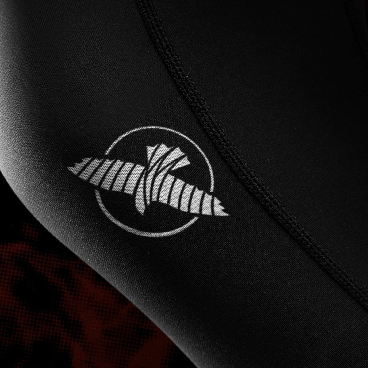 Close up of the official UFC logo and graphics printed on the leg of the black and red women's BJJ leggings