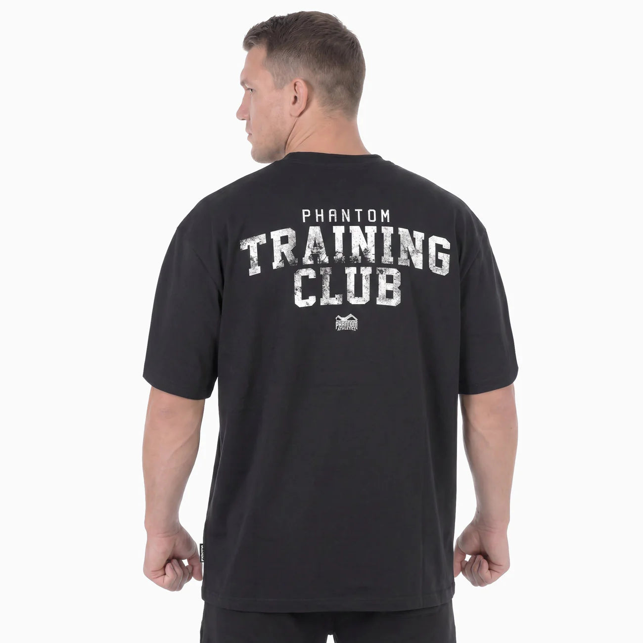 Vista posteriore della t-shirt oversize nera Phantom con la grande scritta grafica Training Club sul retro