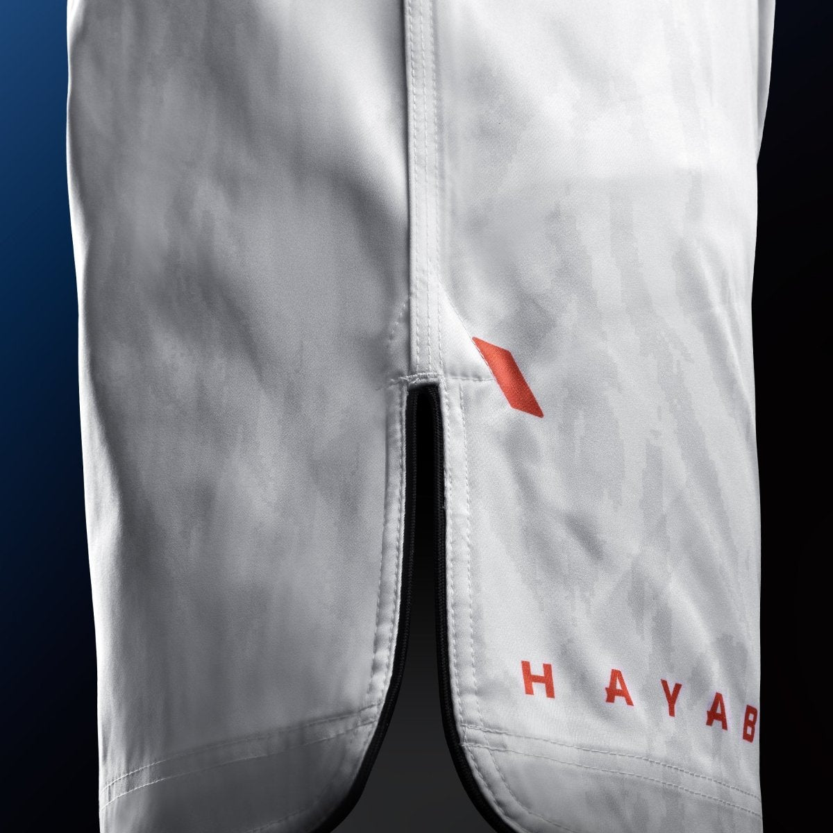 Vista lateral do short branco Hayabusa Apex Mid-Thigh MMA com detalhes de ventilação para máxima mobilidade