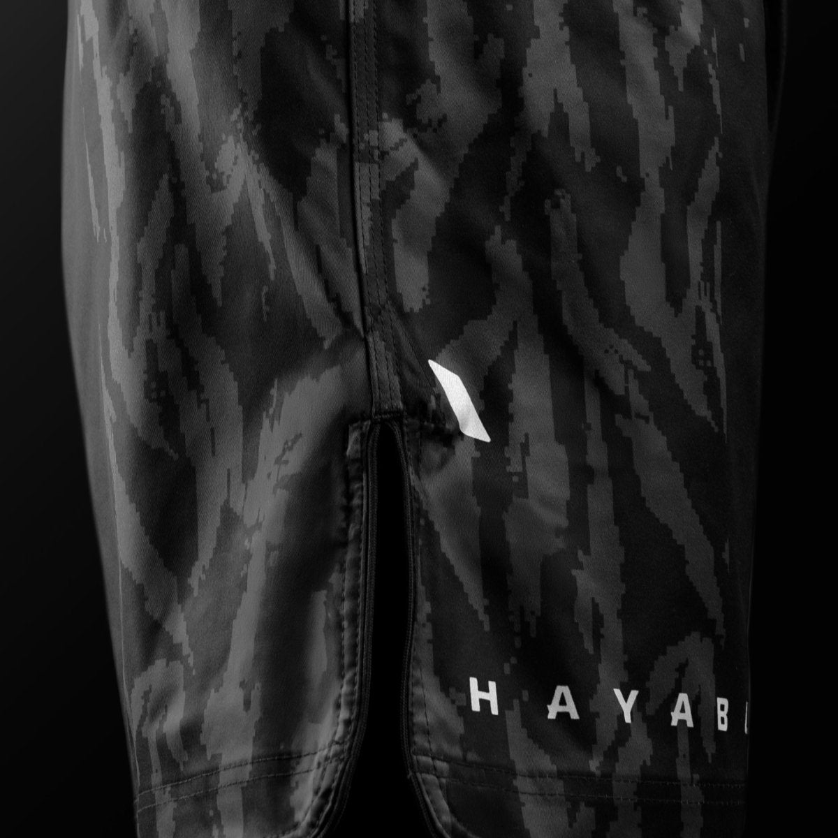 Vista lateral do short preto Hayabusa Apex Mid-Thigh MMA com detalhes de ventilação para máxima mobilidade