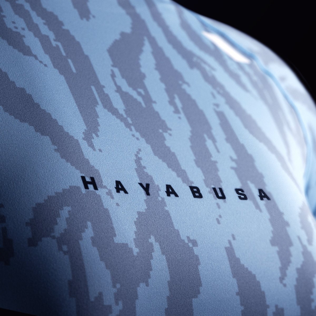 Detail of the Hayabusa writing on the chest of the light blue rashguard, focus on the weave of the 200 GSM fabric